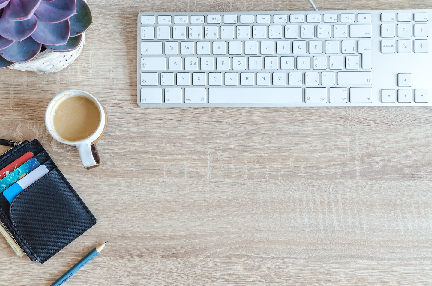 laptop with wallet and coffee next to it